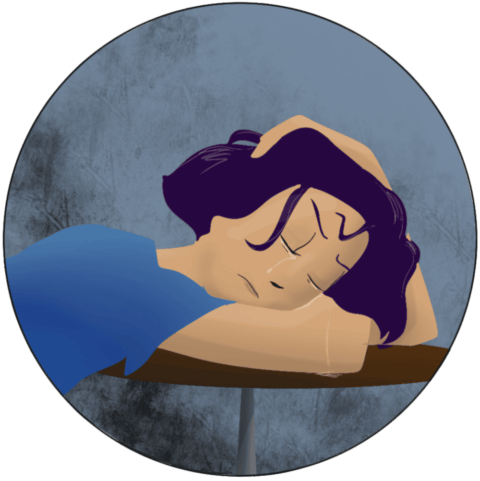 Femme en pleurs, avachie sur une table, la tête sur ses bras.